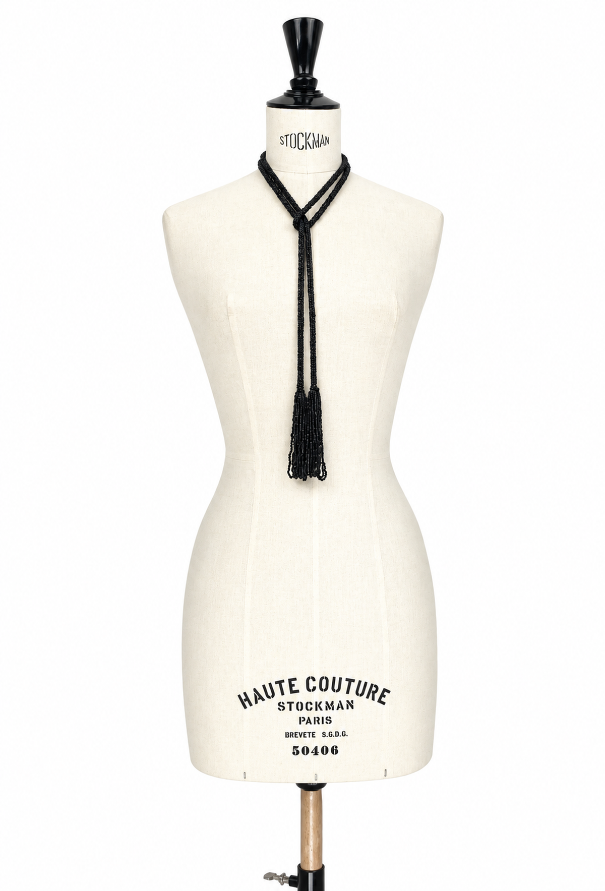 Black lariat necklace with hanging tassel cords on cream mannequin