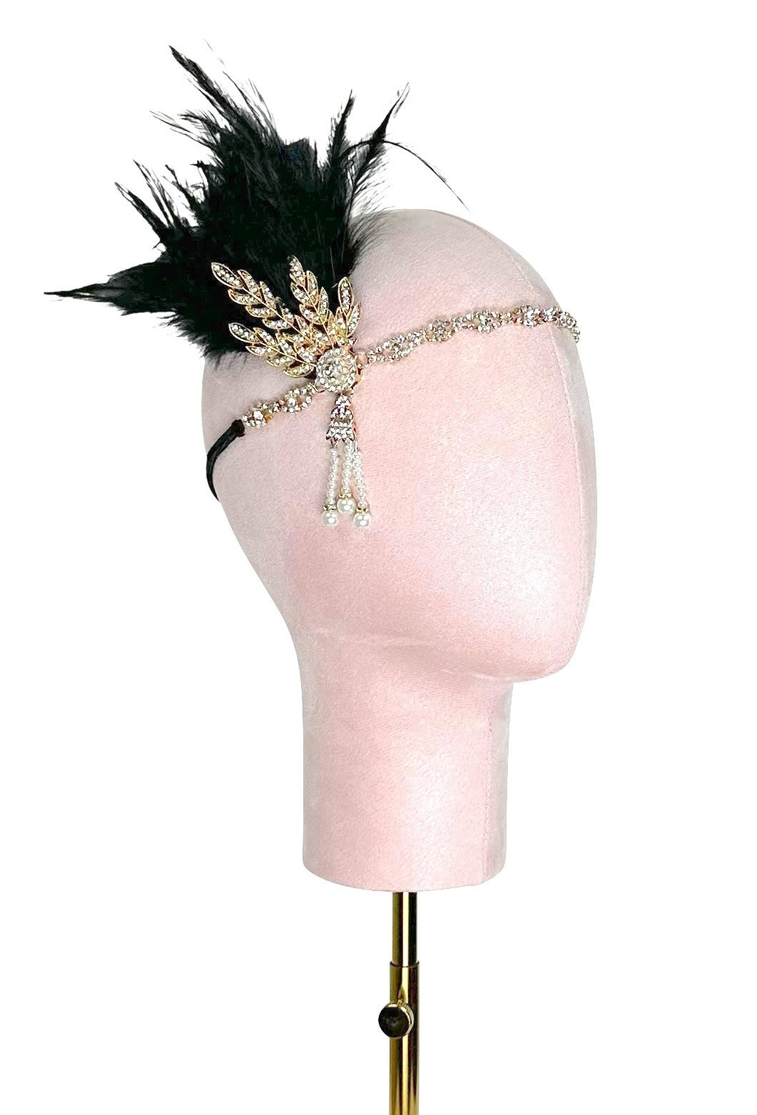 Black feather headband with ornate gold cross centerpiece and crystal accents on form