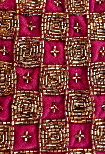 Fuchsia velvet fabric with dense gold beadwork and small gold bead accents