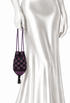Velvet drawstring pouch with purple check pattern, held by long cord straps
