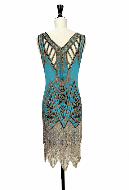 Back view teal V-neck gown with gold beadwork and draped fringe skirt