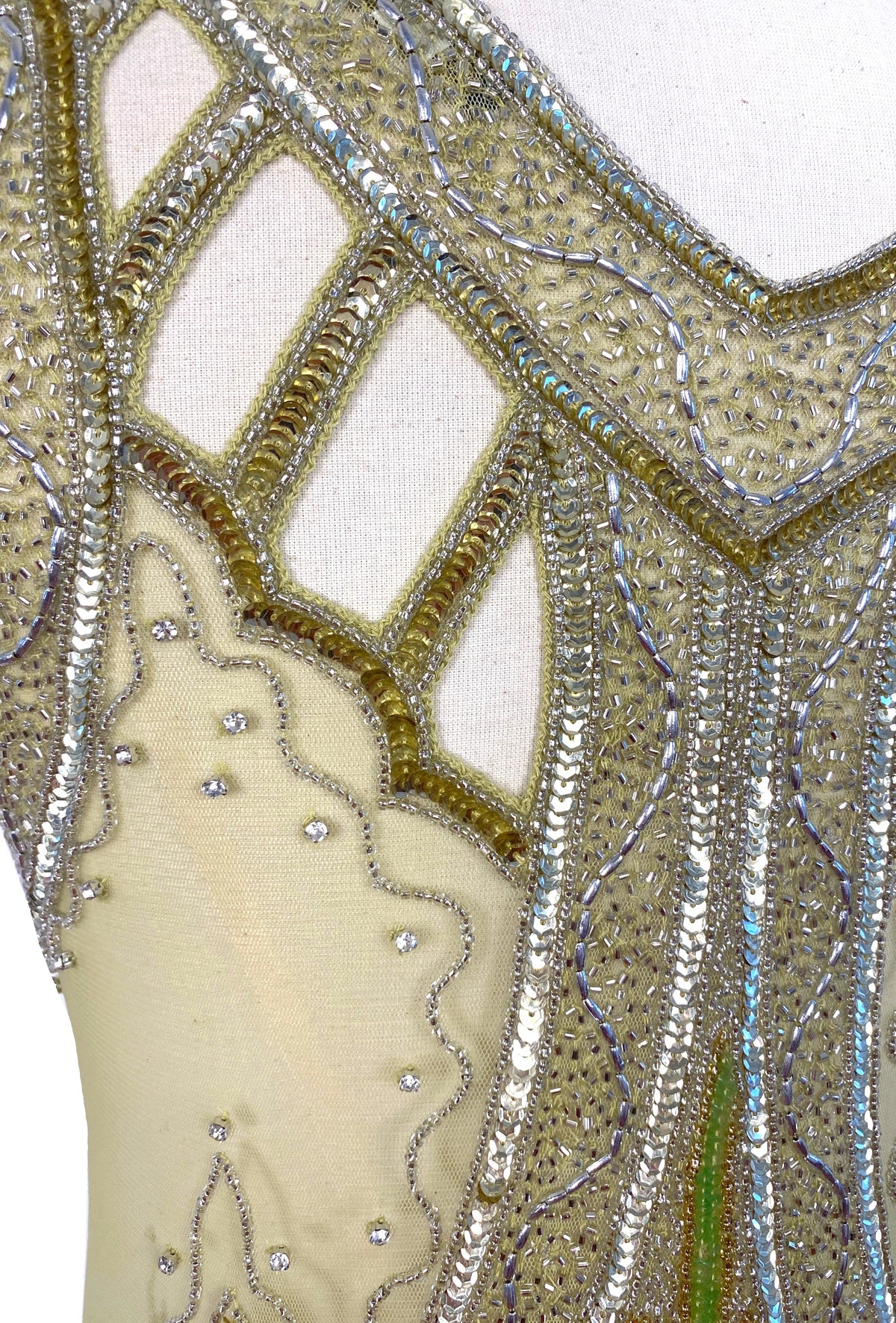 Icon gown Jardin close-up, gold mesh beading with red and green floral motifs