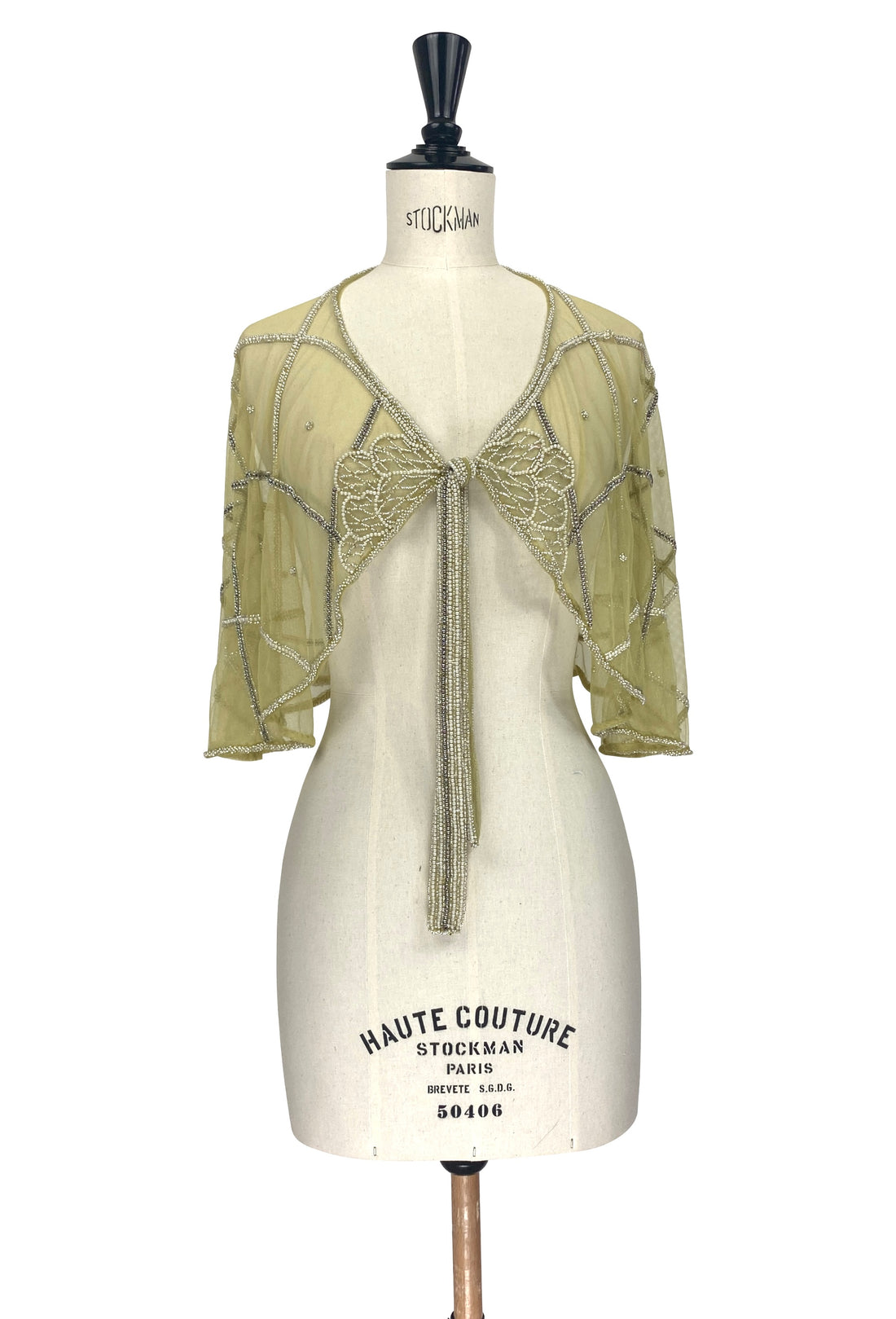 Sheer gold-green capelet with lace yoke, scalloped trim, and long tassel tie