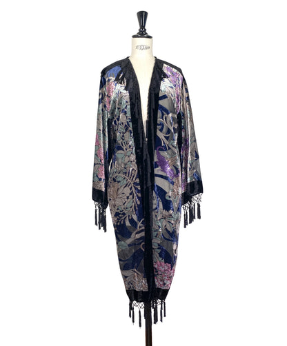 Velvet kimono with dark base, ornate floral face print, open front, fringe trim