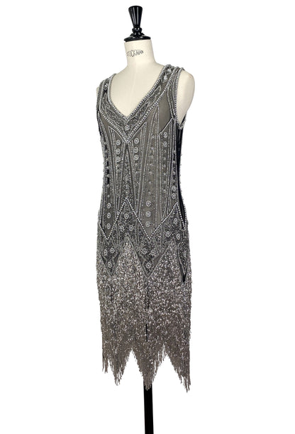 Sleeveless V-neck beaded gown with vertical motif details and fringe at the hem.