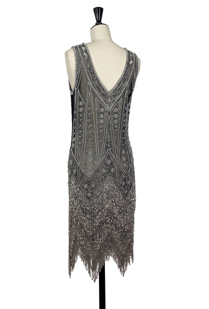 Silver-toned beaded sheath dress with V-neck, intricate patterns, and long fringe hem.