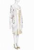Ivory embroidered silk jacket with floral patterns, gold trim, and fringe hem