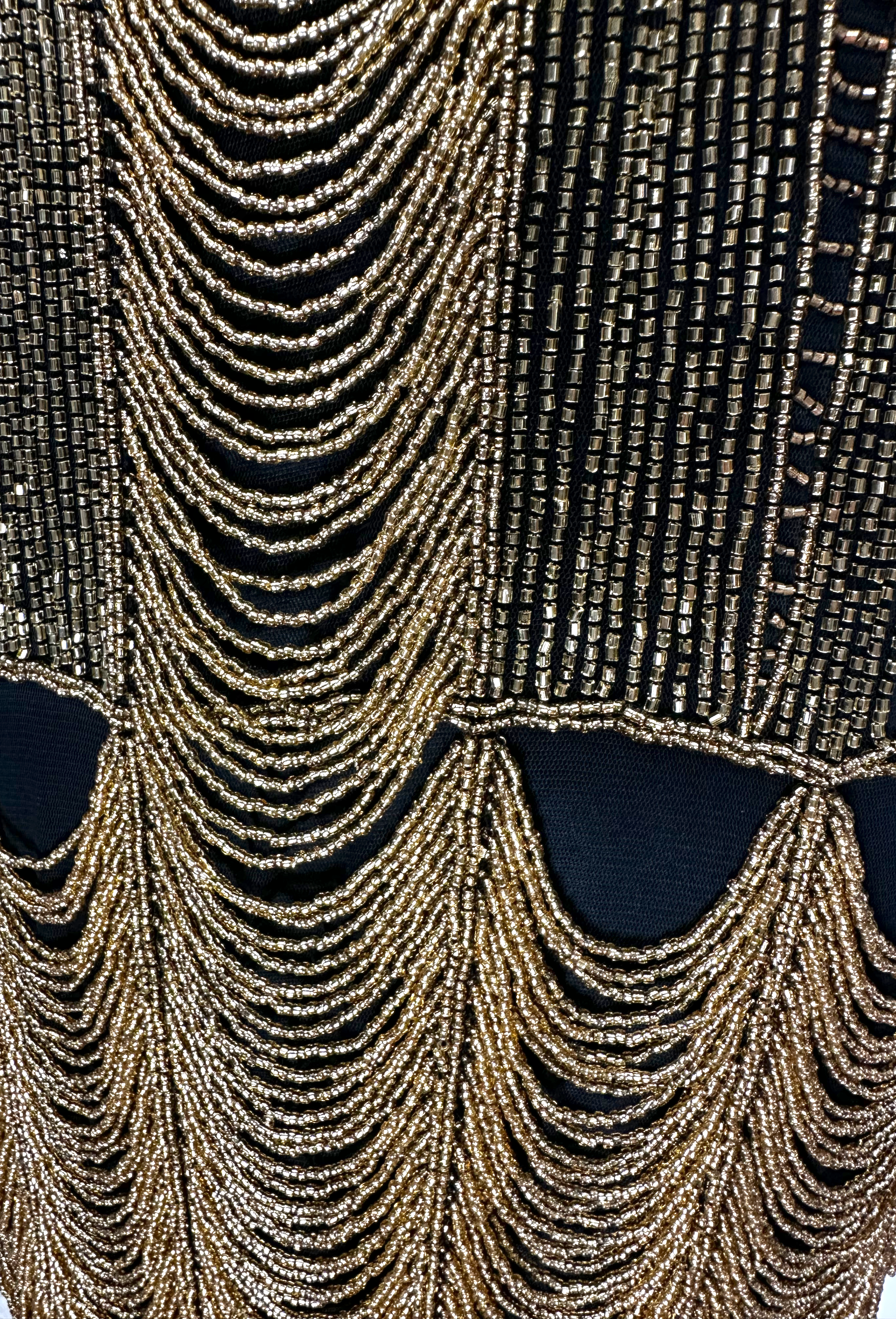 Close-up of gold and black beaded chain fringe on sleeveless dress