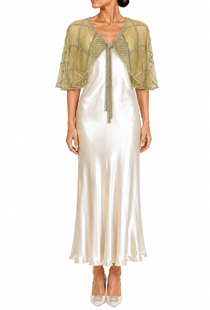 Gold sheer capelet with short sleeves, embroidered trim, and tie at center neckline