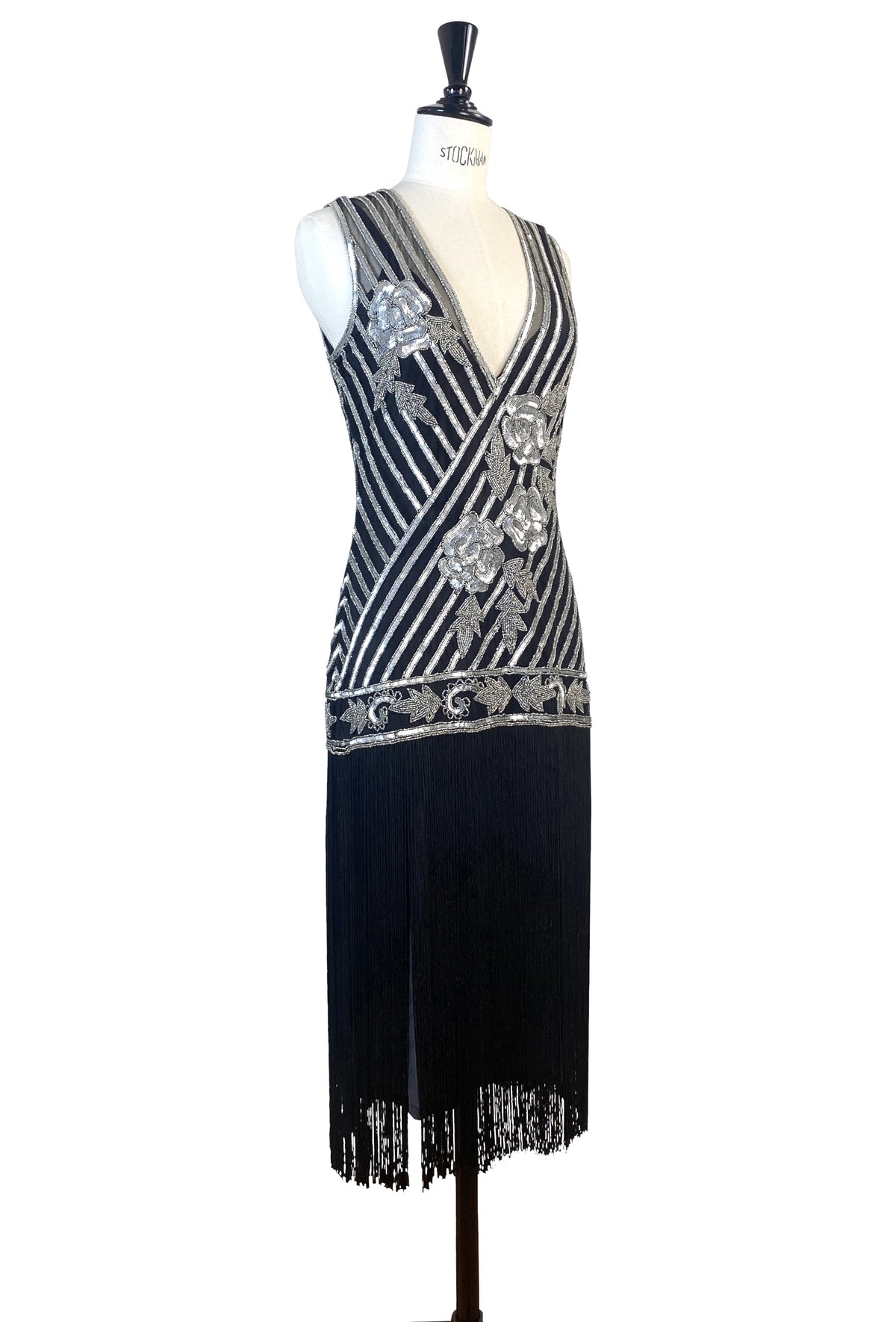 Sleeveless silver-and-black striped gown with ornate beaded motif and tassel fringe hem