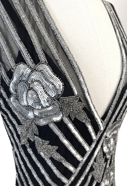Close-up of silver beadwork and striped sequin panels on dark V-neck gown