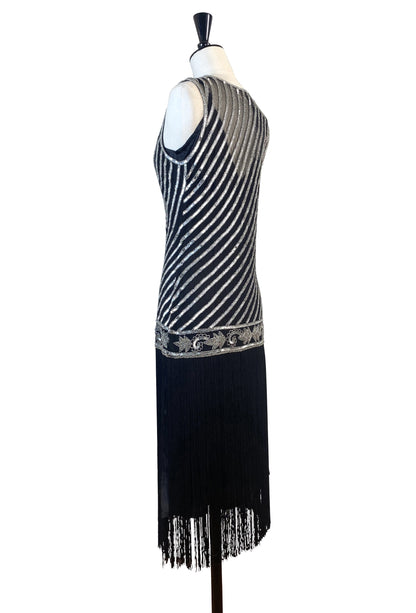 Silver beaded art deco gown with striped sequin panel and fringe hem over dark base