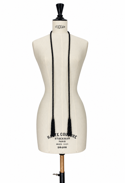 Black tassel lariat necklace with braided cord drape on mannequin