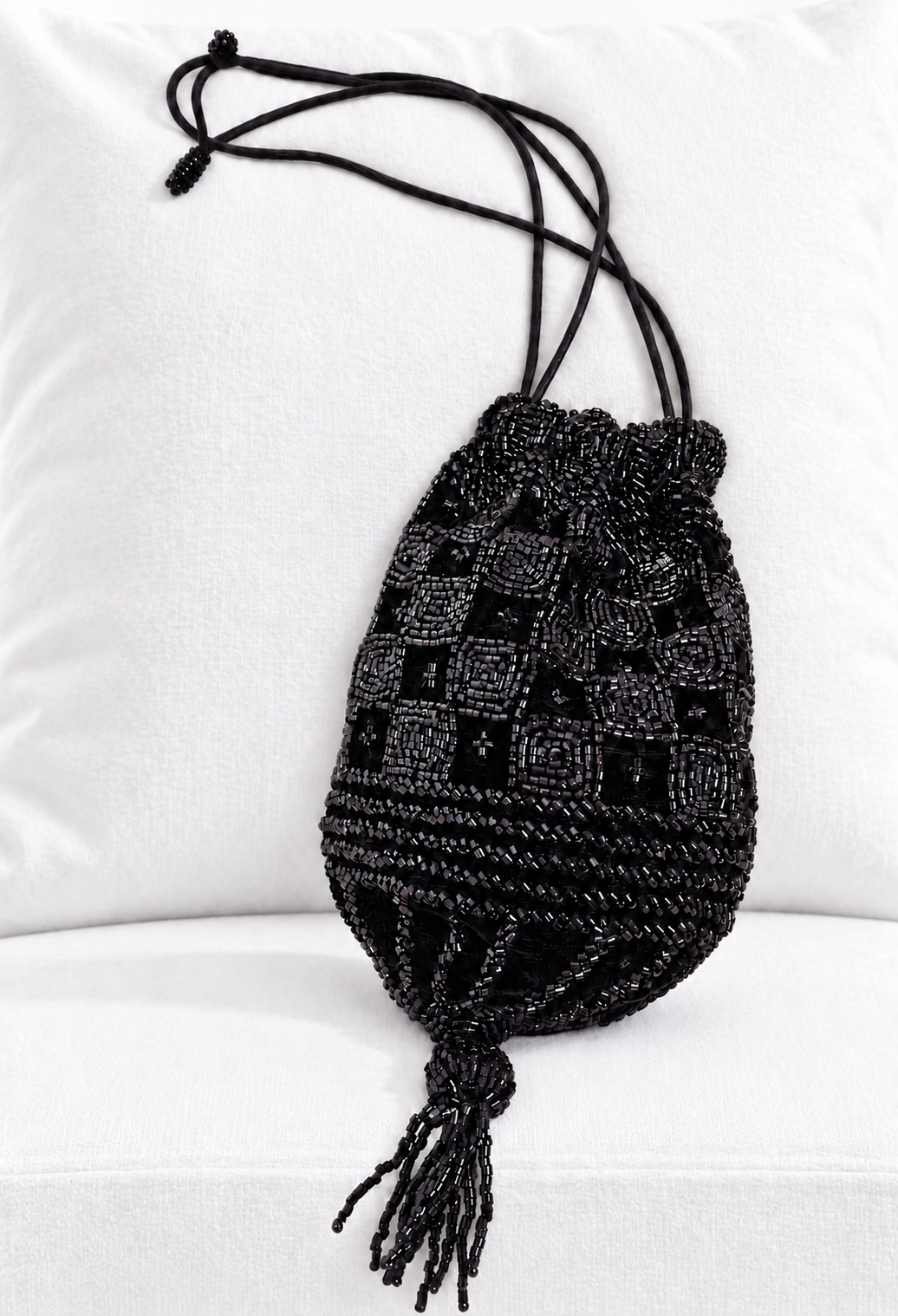 Black velvet drawstring pouch with textured patchwork pattern and long tassels