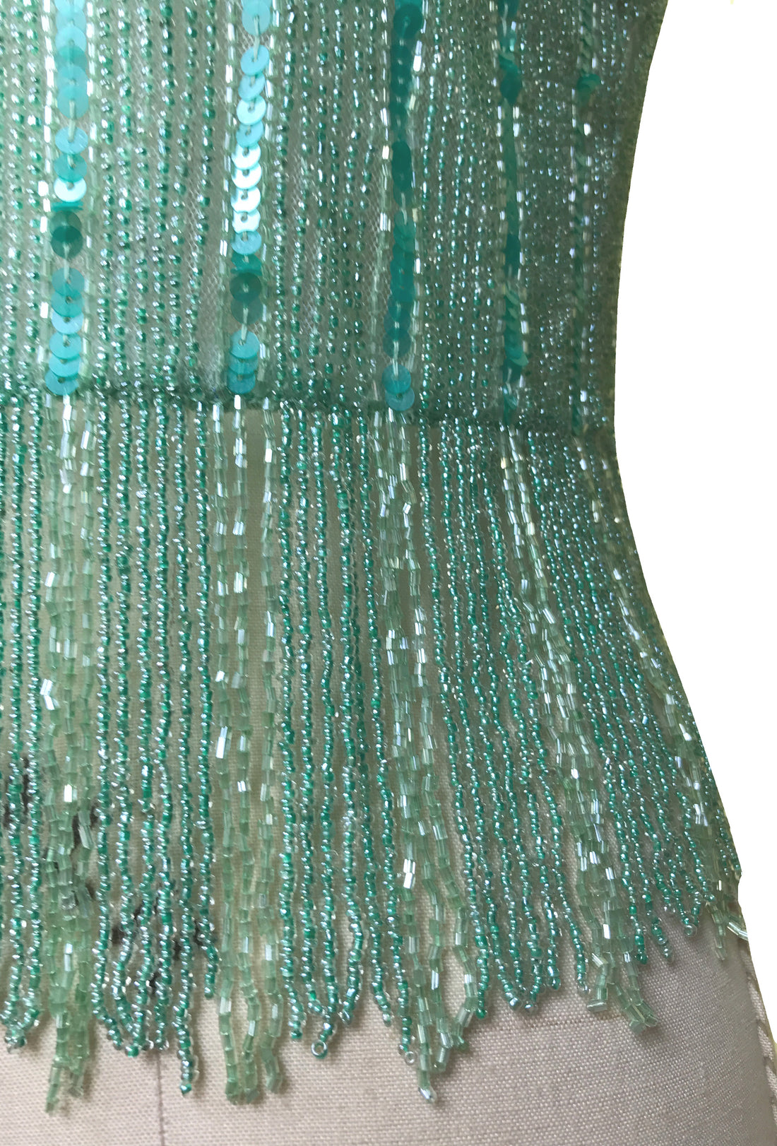 Close-up of verdigris sequin bead strands with cascading fringe hem