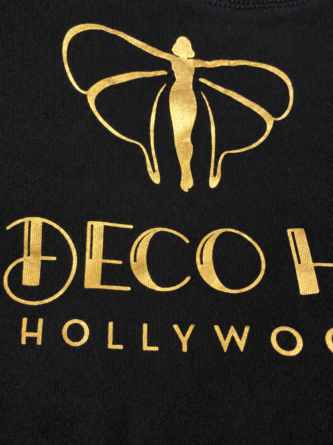Black studio tee with gold foil angel graphic and Deco Haus lettering