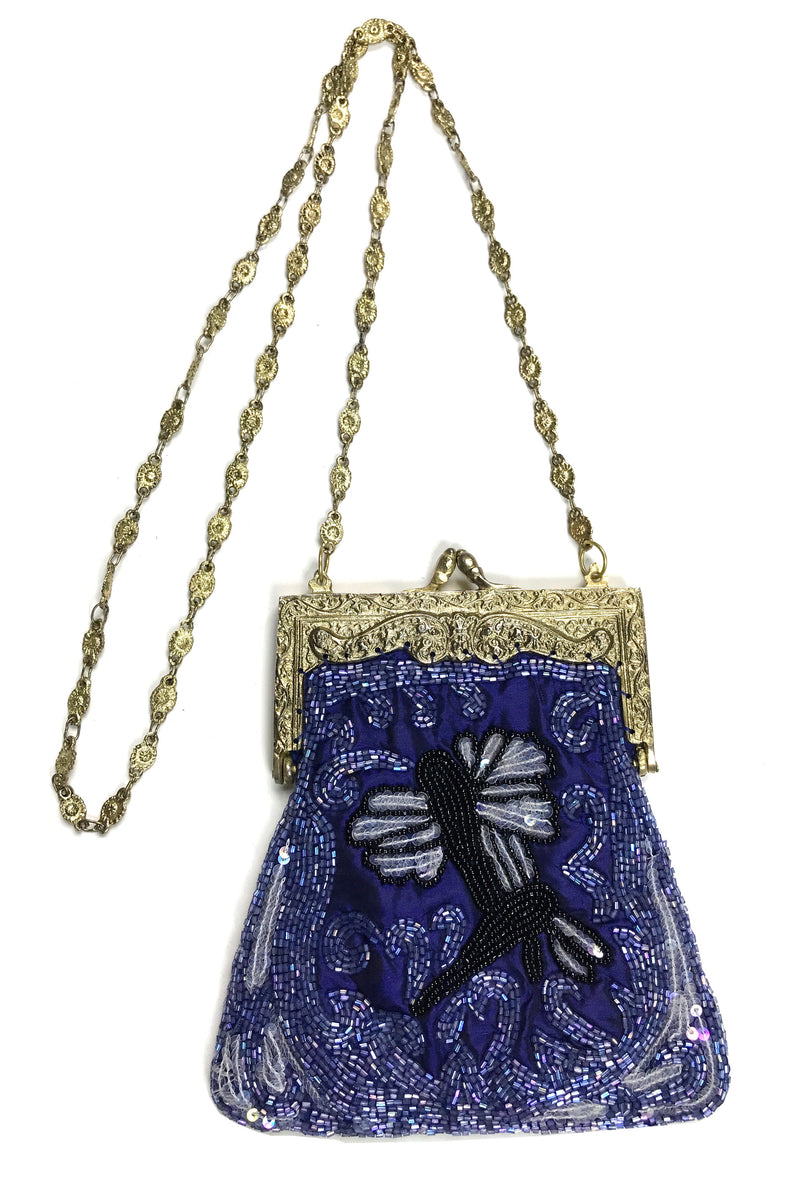 Evening bag made of glass breathing, with three-embroidered silver-colored  silk flowers on either side. Evening bag made of glass batteries in a  shield form, along which the entire edge has a pleated
